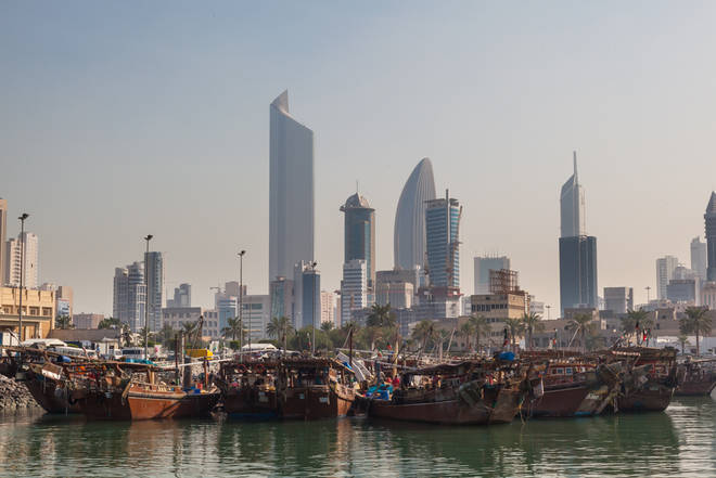 Kuwait City - traditionelle Fischerboote vor ultramodernen Hochhausfassaden